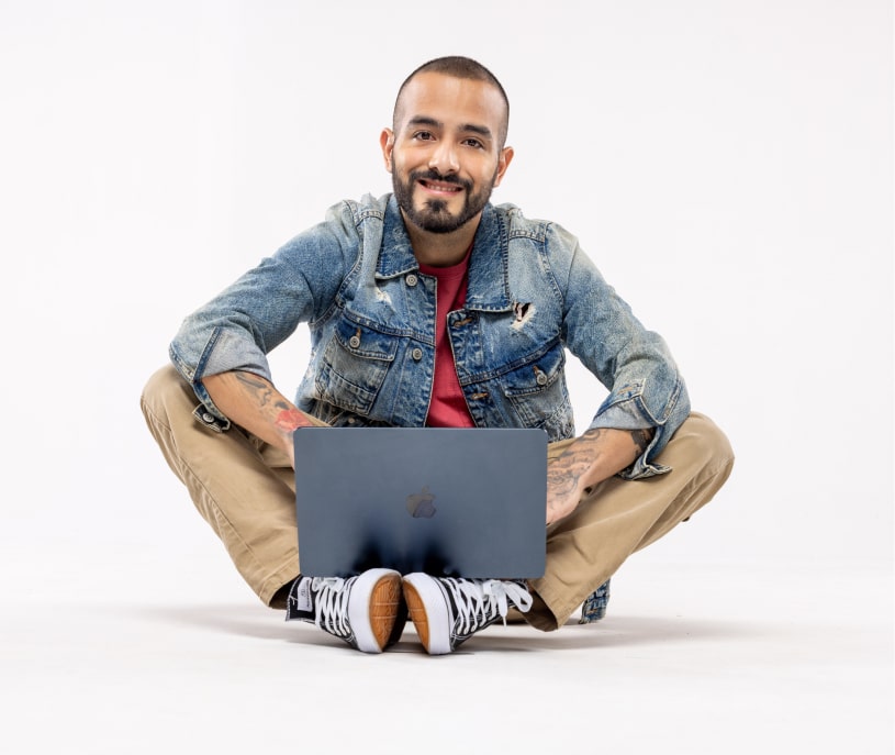 Hombre sentado en el suelo con una laptop en las piernas